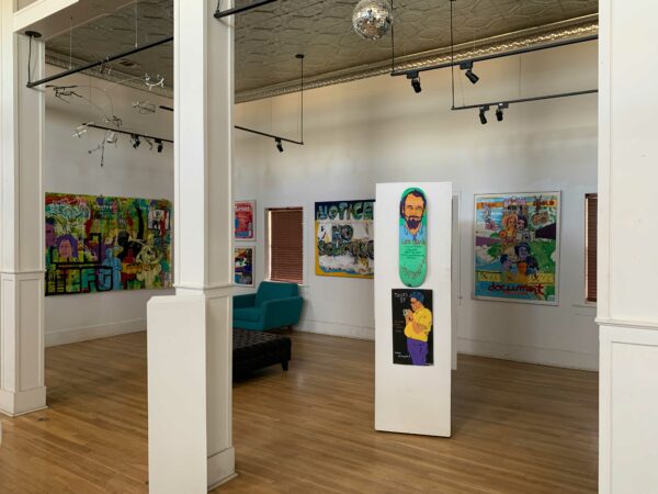 Multiple artworks are densely installed in a gallery space.