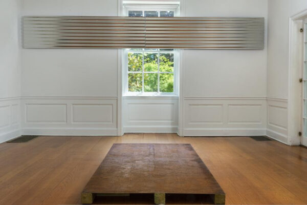 A photograph of a large corrugated steel sculpture hung in a home. Artwork by Tahir Karmali.