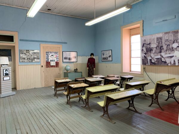 A recreation of an old school room, featuring period desks along with photos and other ephemera.
