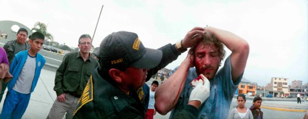 Photo of an officer helping a man with a bleeding face