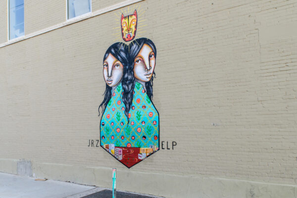 Mural of two women with their backs to one another