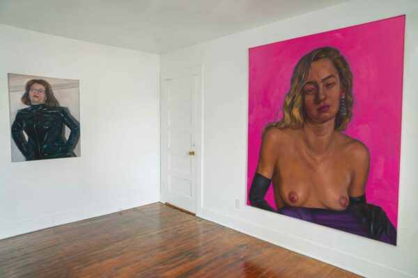 Installation view of two paintings of women