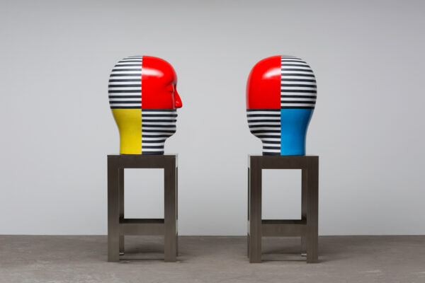 An installation image of two abstract bust sculptures facing each other.