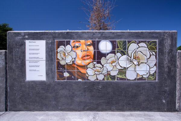 A close-up photograph of a section of a wall at Poet's Pointe that features a poem by Josh Robbins and an artwork by Debora Kuetzpal Vasquez. 