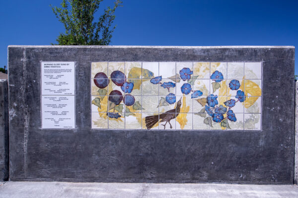 A close-up photograph of a section of a wall at Poet's Pointe that features a poem by Natalia Trevino and an artwork by Margaret Craig. 