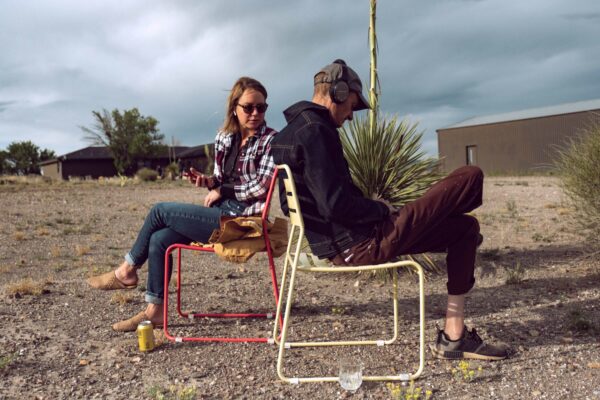 Two people sitting in chairs in the desert