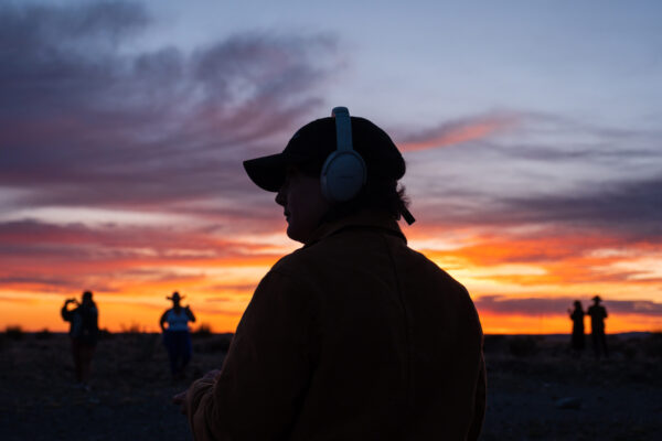 Visitors in the desert wearing headphones