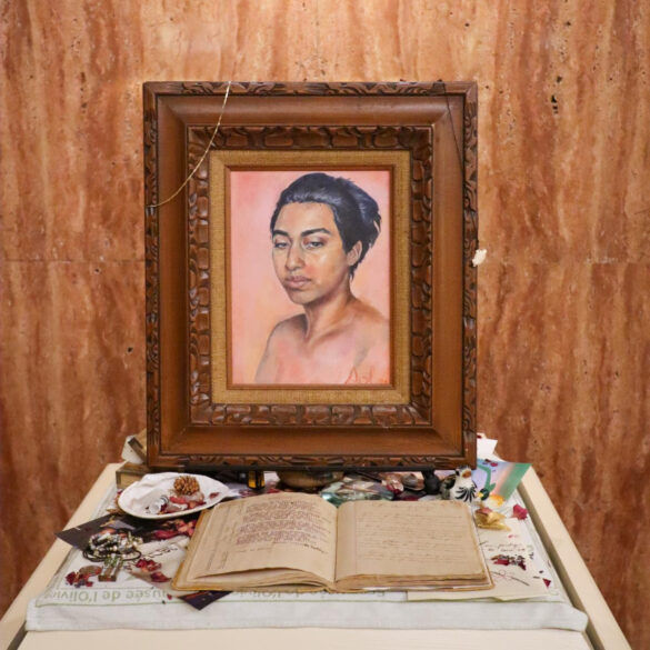 An artwork by Sol Diaz featuring a framed portrait on an alter-like table top.