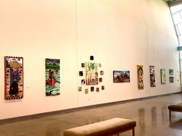 Installation view of tufted works on a white wall