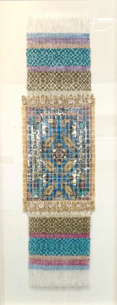 Installation view of a tapestry on a white wall
