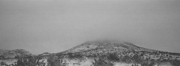 A black and white photograph of a snow covered mountain.