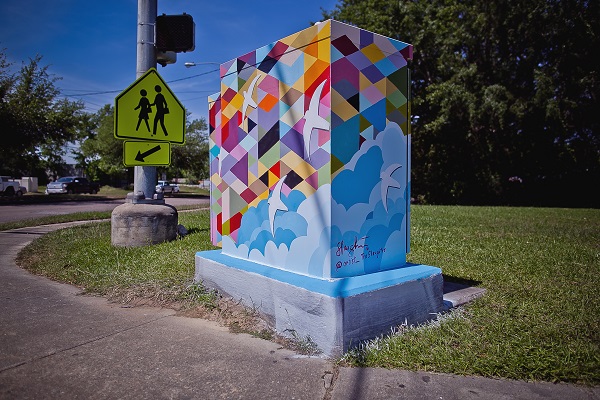 A photograph of an electrical box with a mural by Tra' Slaughter.