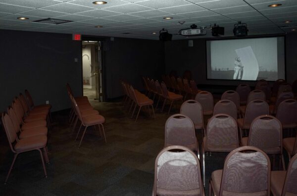 Photo of a room of empty chairs with a projector screen