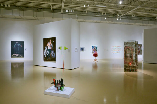 An installation image featuring sculptures and paintings on view in a gallery.