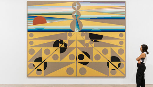 Large scale abstract painting with yellows and blues on a wall