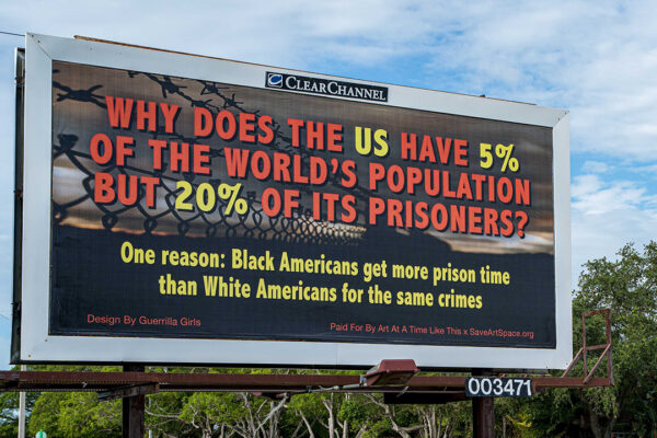 A photograph of a billboard designed by the Guerrilla Girls.