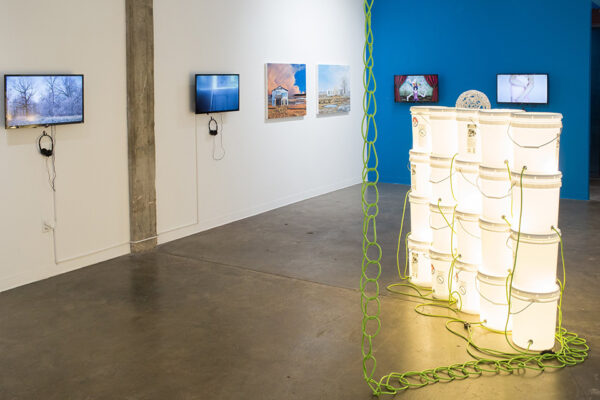An installation image featuring video works, paintings, and an installation in a gallery.