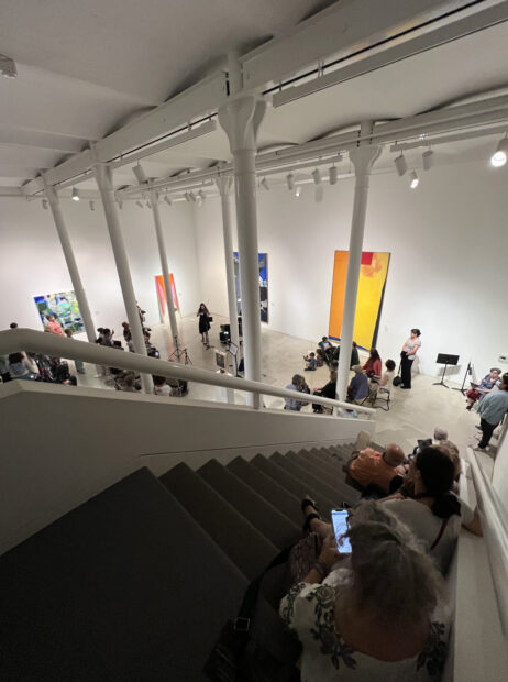 Photo of visitors watching a performance in the hall of a museum