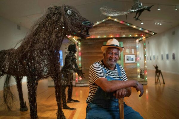 A photograph of Jesse Lott in a gallery of his work.