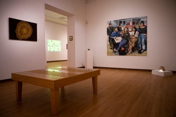 An installation image of various artworks hanging in a gallery.