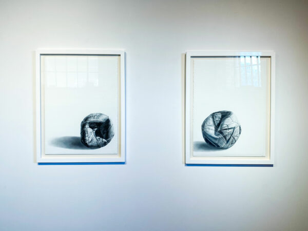 Diptych of two balls that have been kicked in against a white backdrop