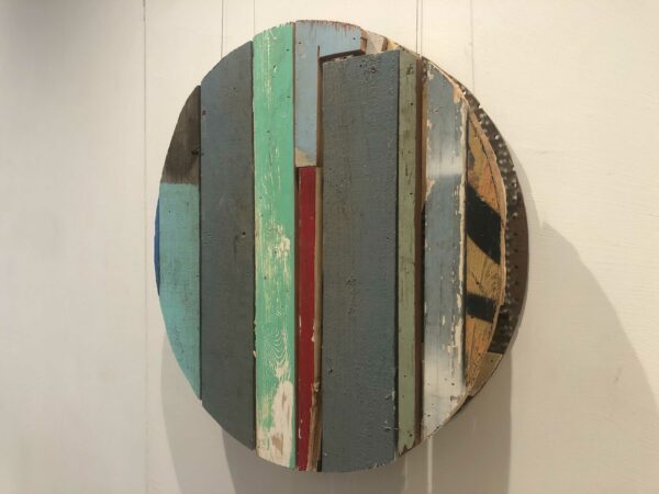 Installation view of a round piece made of colored wood and cardboard