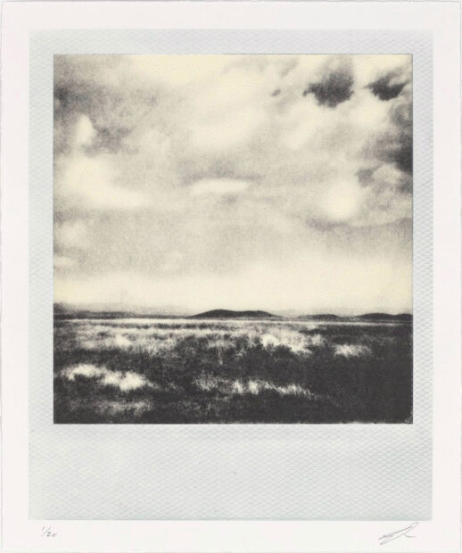 A lithographic print that looks like a polaroid photograph of a desert scene with hills in the background.
