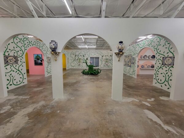 Installation view of an exhibition by Eduardo Sarabia with vine-painted walls and intricate ceramics