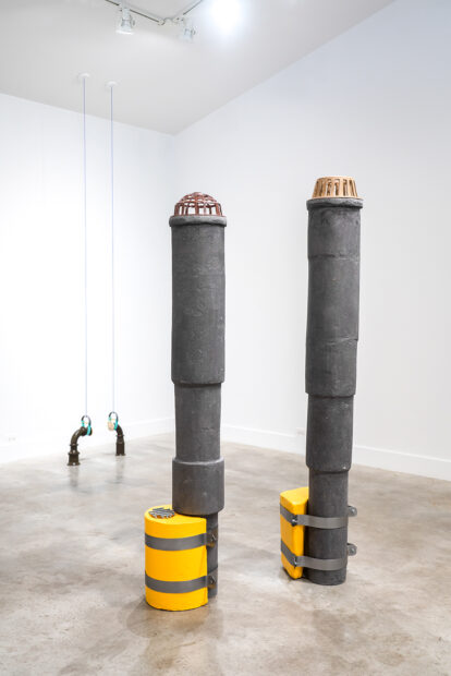 Installation view of two large industrial towers in a gallery space