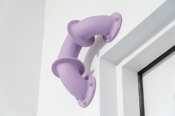 Installation view of a purple pipe in a corner