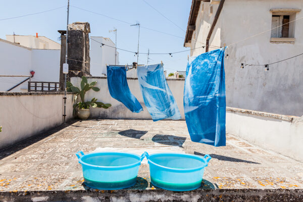 A video still featuring two blue baskets and three blue tarps hung on a clothesline.
