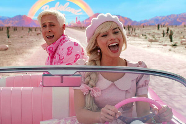 A woman, who is the doll Barbie, sits in the diver's seat of a pink convertible car. Behind her is a blonde man, representing Ken. The pair drive away from "Barbieland."