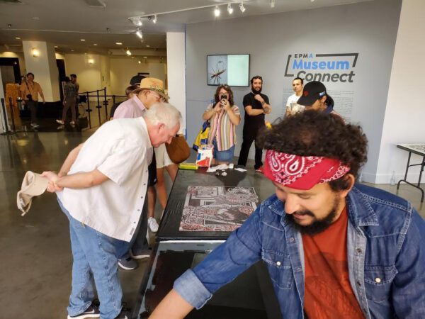 Image of visitors looking at prints on a table