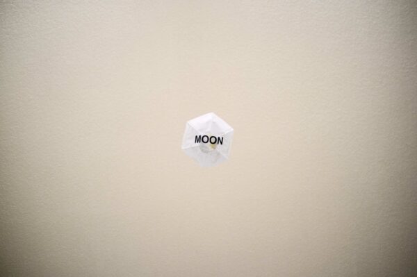 Photo of a piece of paper with the word MOON in black letters
