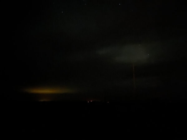A nighttime photograph of lights floating above the distant horizon.