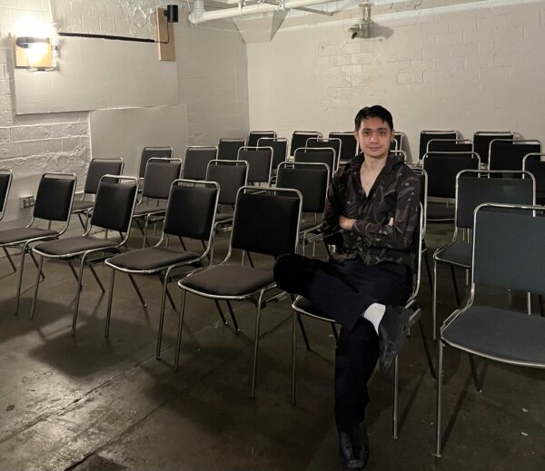 Photo of Tony Nguyen sitting in a room with chairs