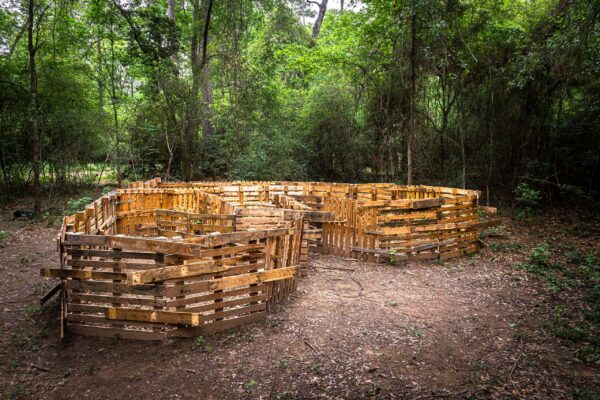 A large sculpture made of wooden pallets, which come together in the shape of a heart.