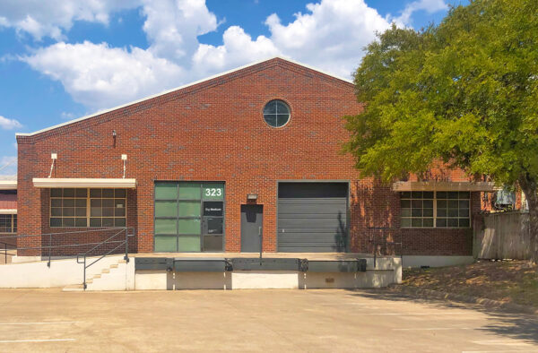 A brick building featuring a few doors and loading bays.