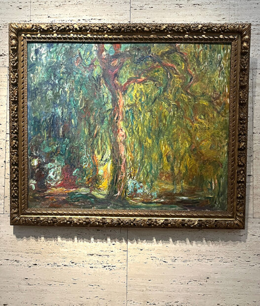 A photograph of a painting by Claude Monet of a willow tree.
