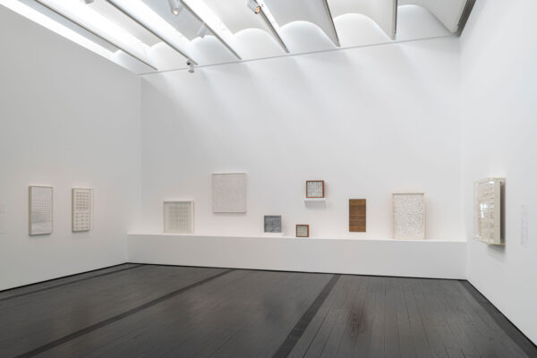 Installation view of two dimensional works on a white wall at the Menil