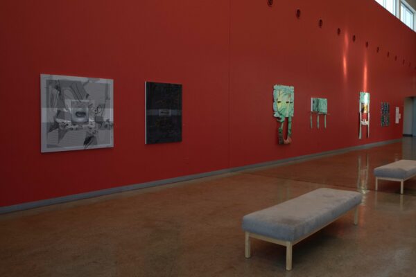Installation view of works on a red wall