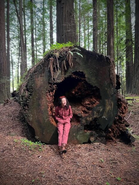 A photograph of filmmaker Sarah Lasley in a forest.