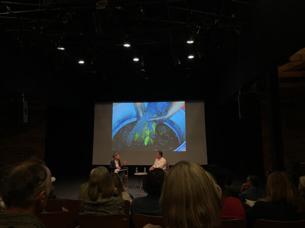 Photo of two panelists sitting in front of a screen
