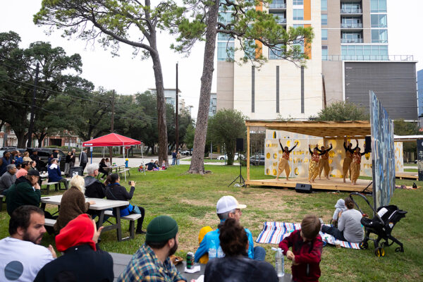 A photograph of a public event taking place at the site of a a public art installation by Opening celebration for Rafael Domenech and Tomas Vu.