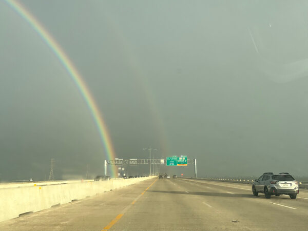 A photograph of a double rainbow appearing in the distance.