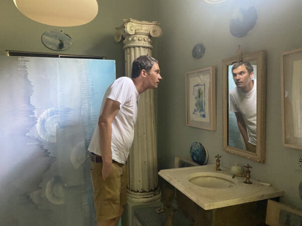 Photo of Glasstire contributor Valentin Diaconov looking in a mirror
