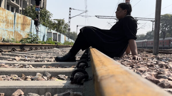 Photo of a person siting on train tracks