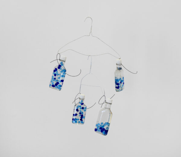 Installation of vodka bottles with blue dots hanging on a clothes hanger