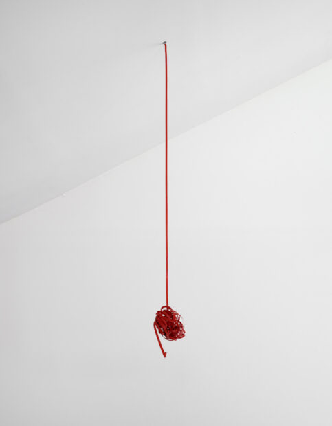 Sculpture of a piece of string hanging from the ceiling and knotted at the bottom