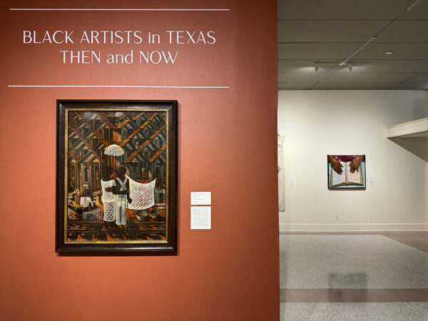 An installation image featuring a work by John Biggers in the foreground and a painting by Sedrick Huckaby in the background.